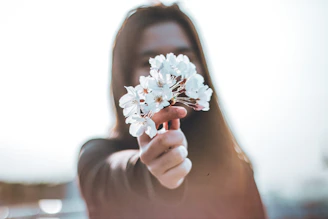 a woman holding a flower in her hand