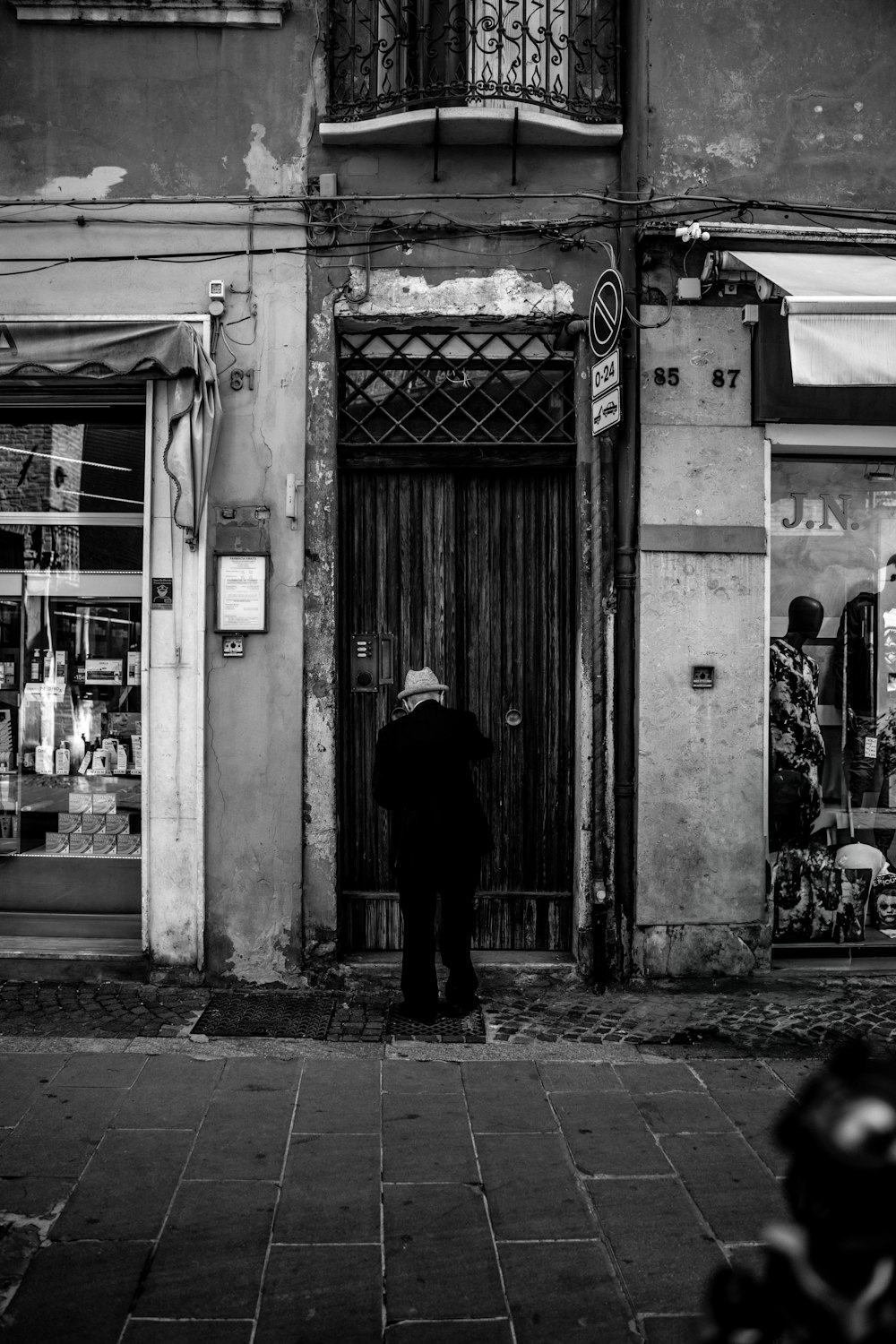 Una foto in bianco e nero di un uomo in piedi di fronte a un edificio