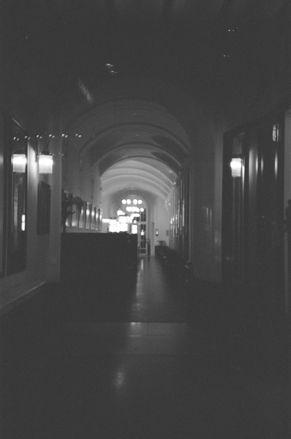 a black and white photo of a long hallway