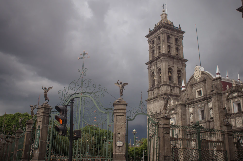 Vista de una calle y torre de campanario en el centro de Puebla, México.