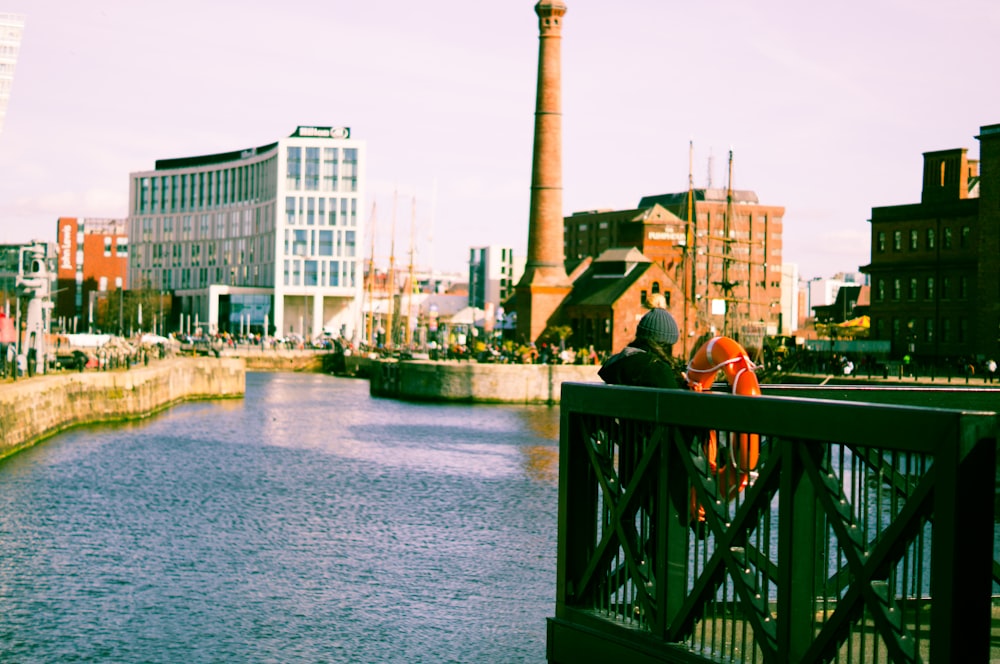 um casal de pessoas em pé em uma ponte sobre um rio