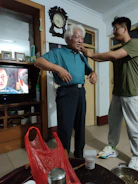 A caring volunteer helping an elderly man with his daily tasks at home