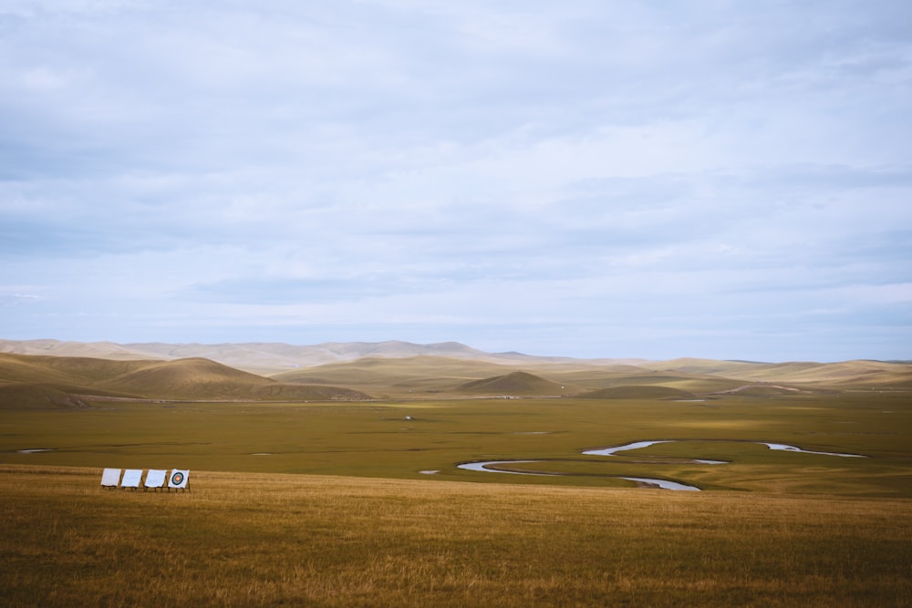 a field with a few hills in the distance