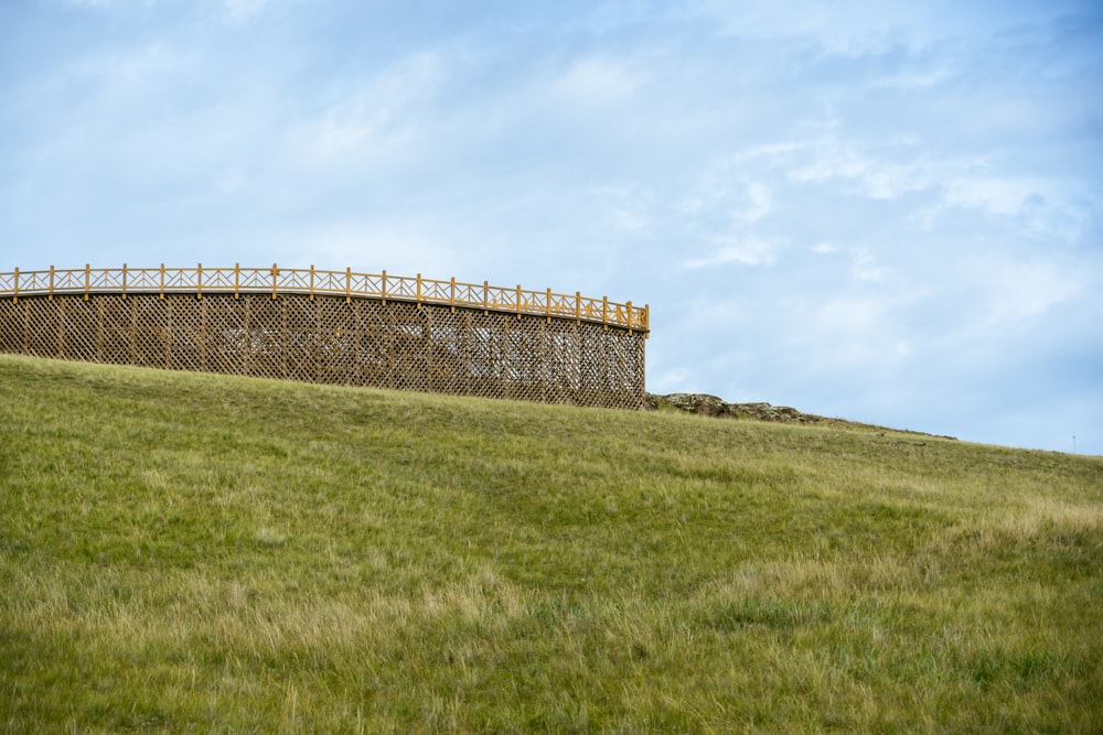 a grassy hill with a fence on top of it