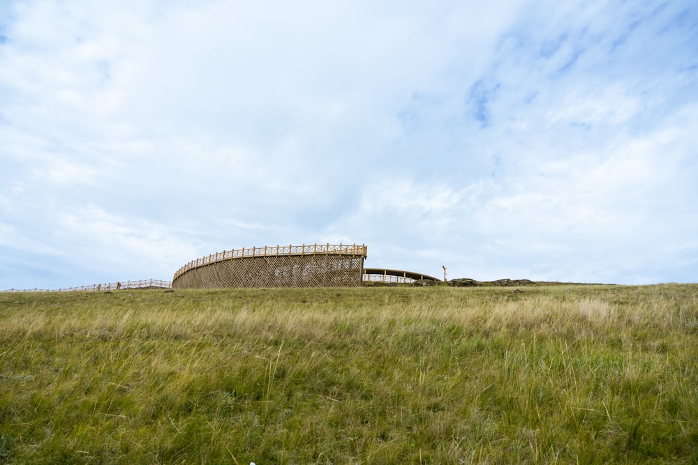 a grassy field with a structure in the middle of it