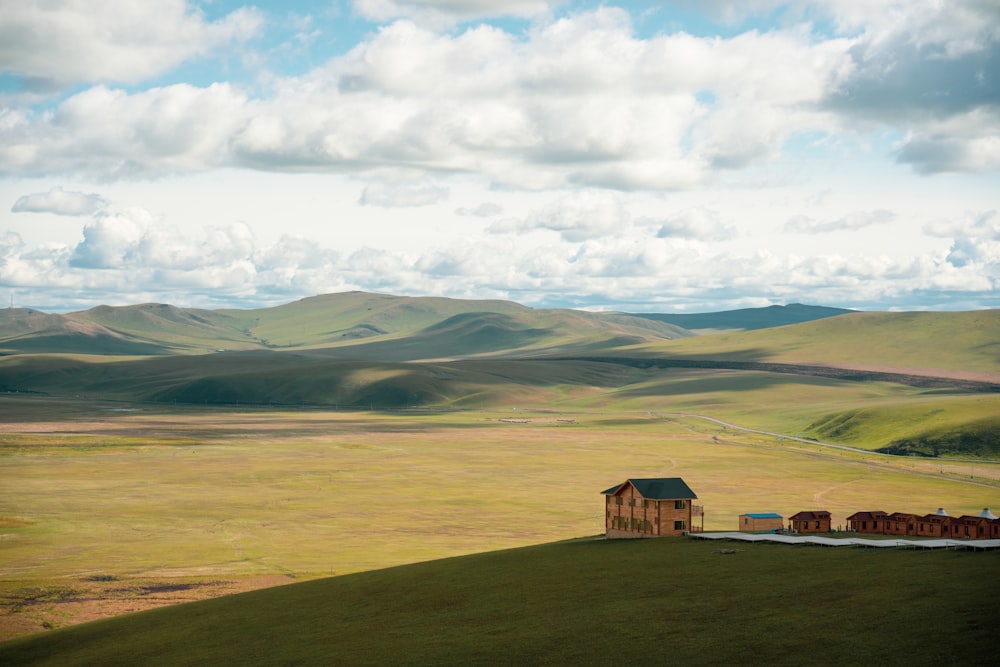 a house on a hill with mountains in the background