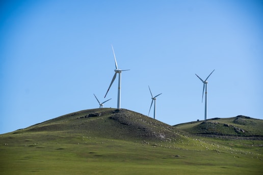 a group of wind turbines on top of a hill
