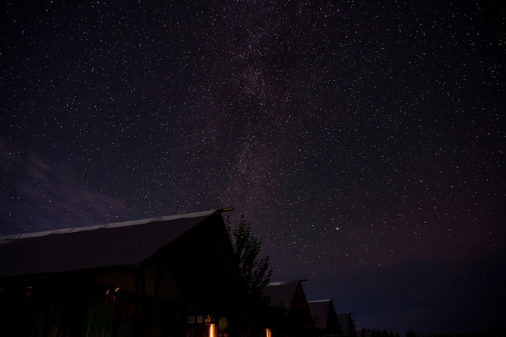 the night sky with stars above a house