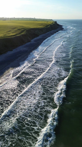 an aerial view of a beach with waves coming in