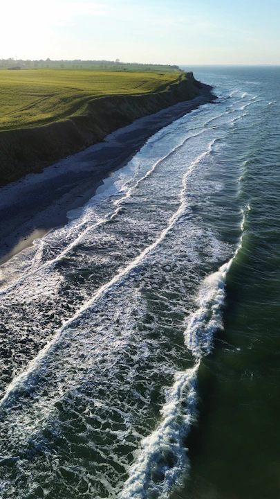 an aerial view of a beach with waves coming in