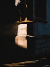 Before and after photo of masonry work on a rustic stone wall bathed in warm sunlight.