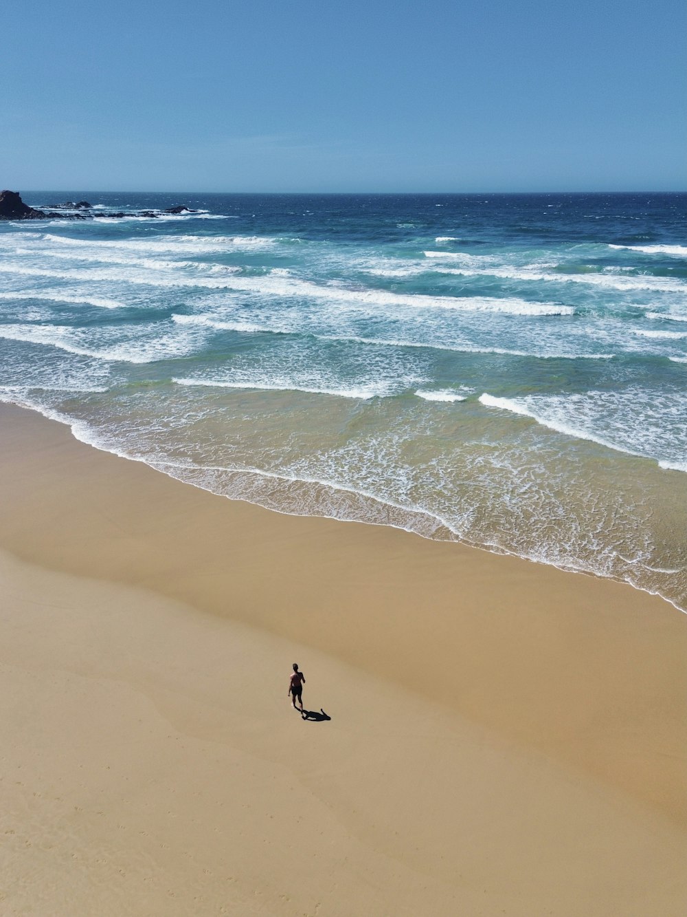 a person standing on a beach next to the ocean