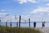 a group of people playing volleyball on the beach