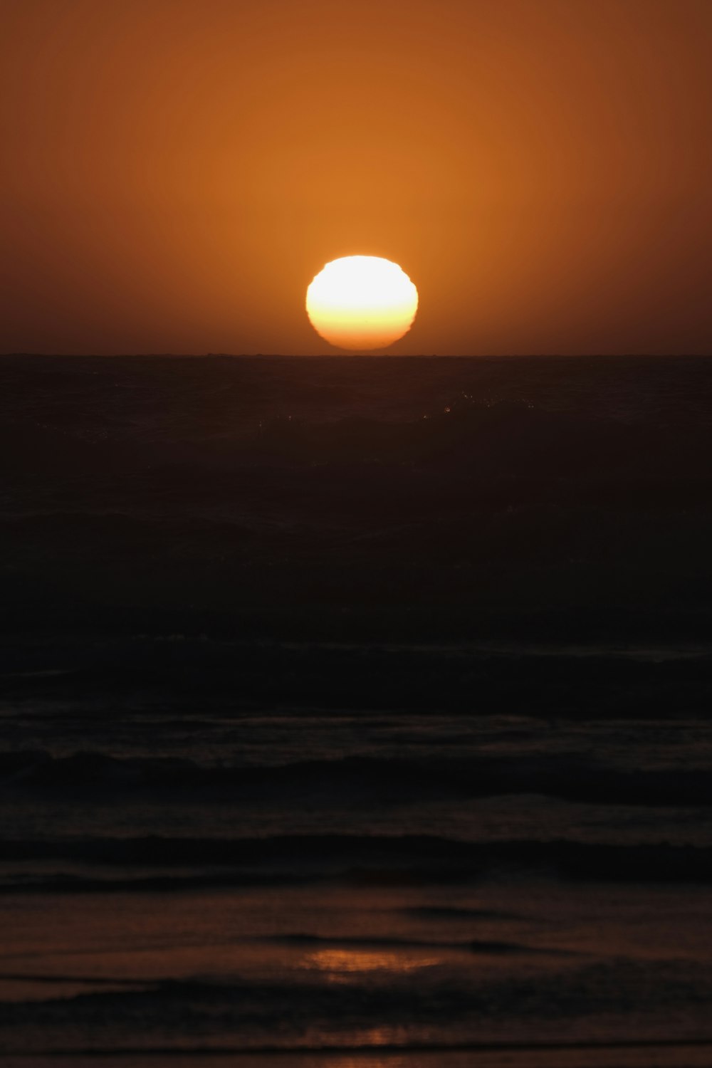 the sun is setting over the ocean with waves