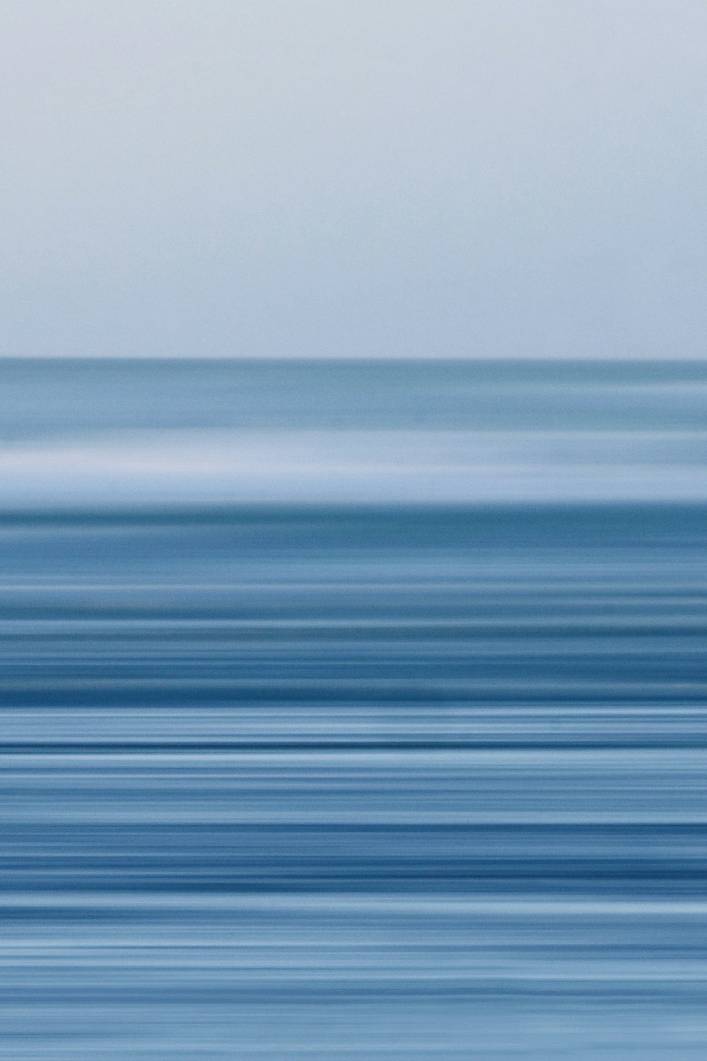 a blurry photo of a bird flying over the ocean