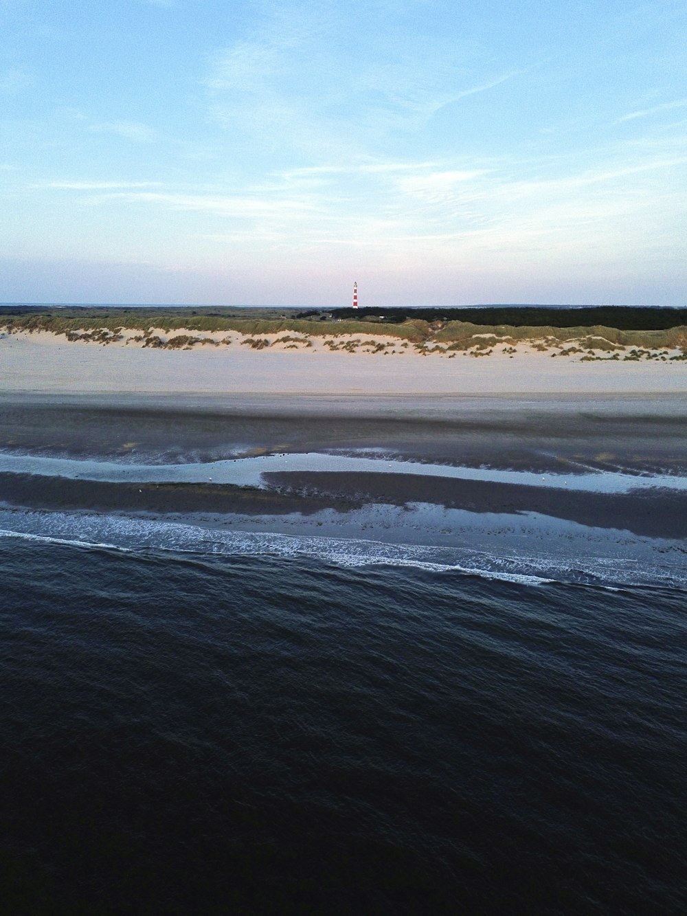 a view of a beach with a lighthouse in the distance