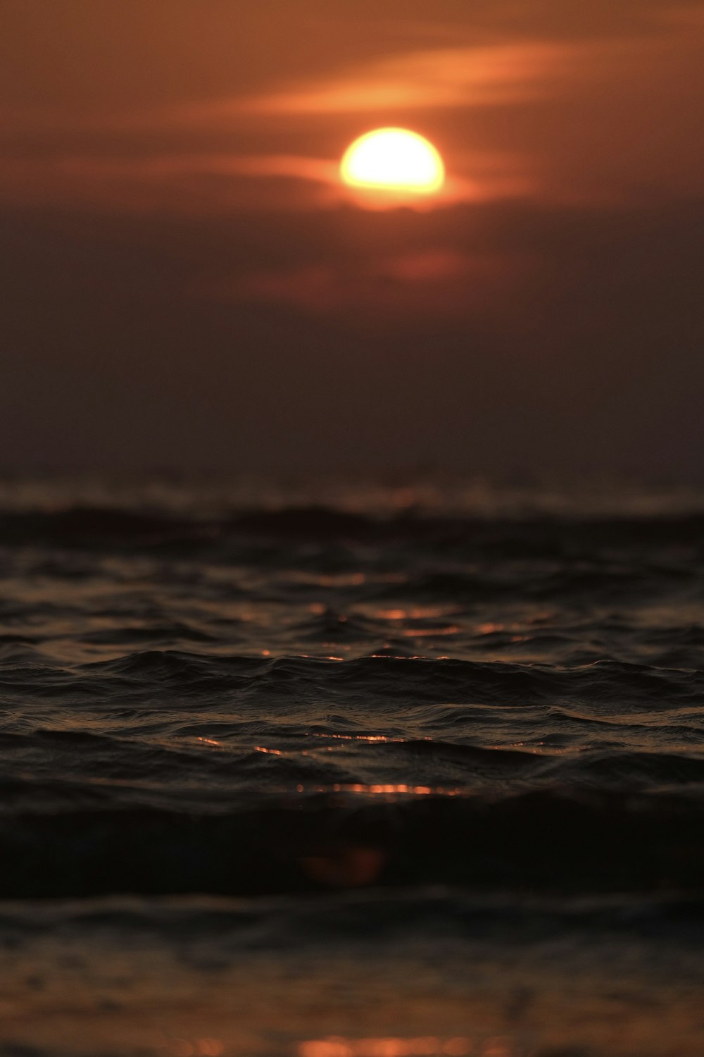 the sun is setting over the ocean with waves