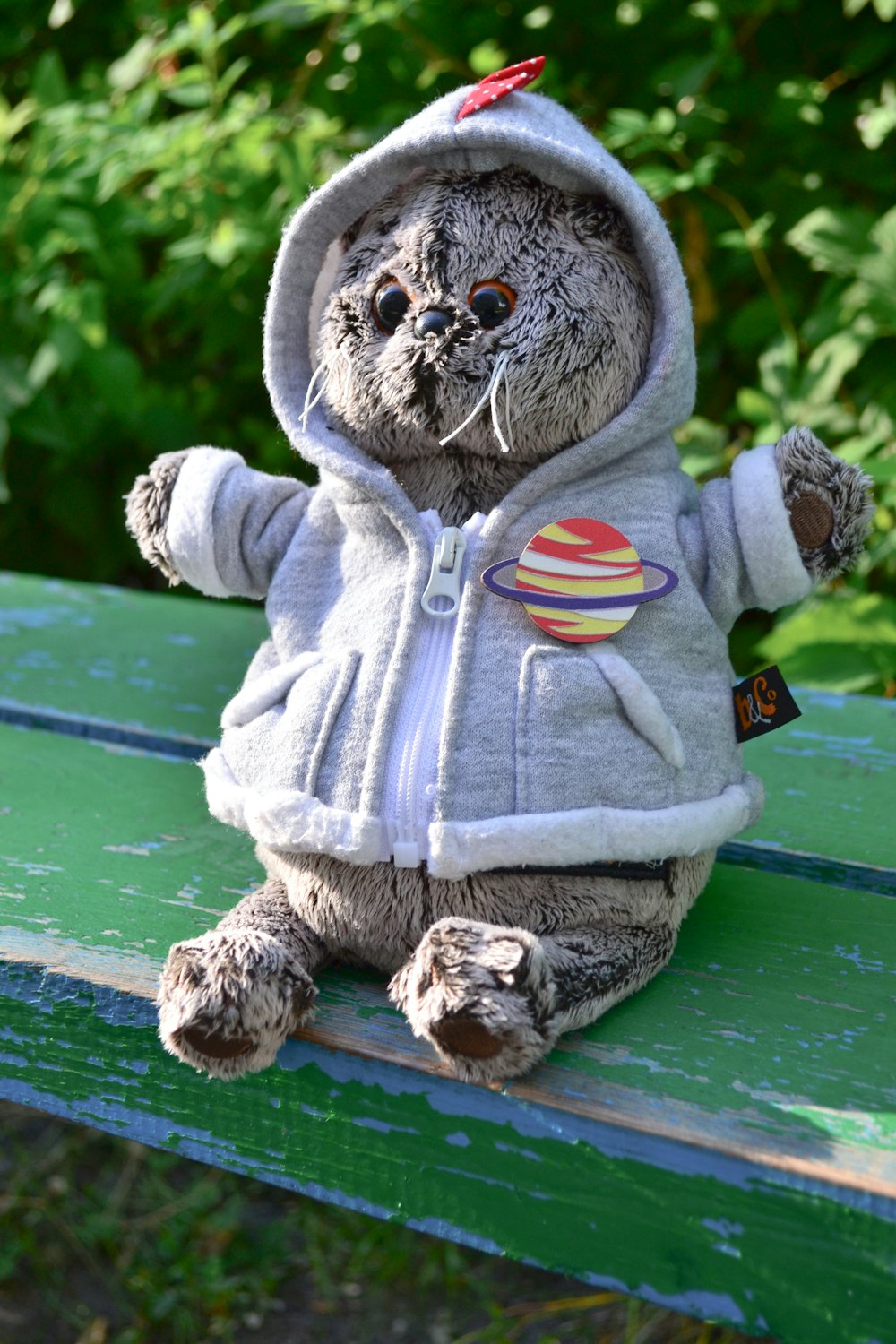 a stuffed animal sitting on top of a green bench