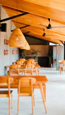 A modern cafe interior with wooden tables and plants.