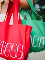 a woman carrying two red and green shopping bags