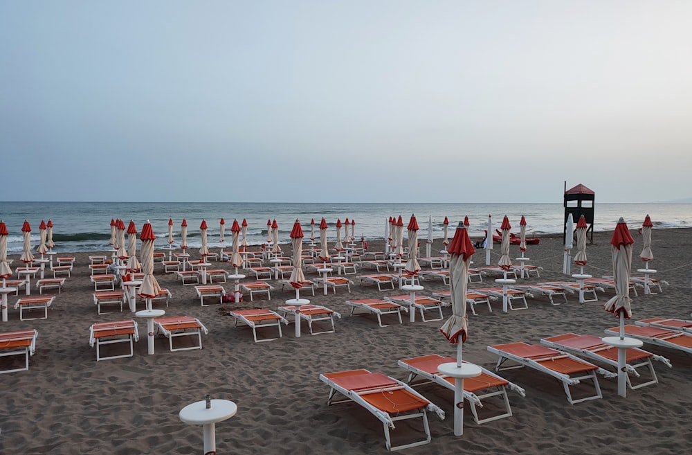 a bunch of chairs and umbrellas on a beach