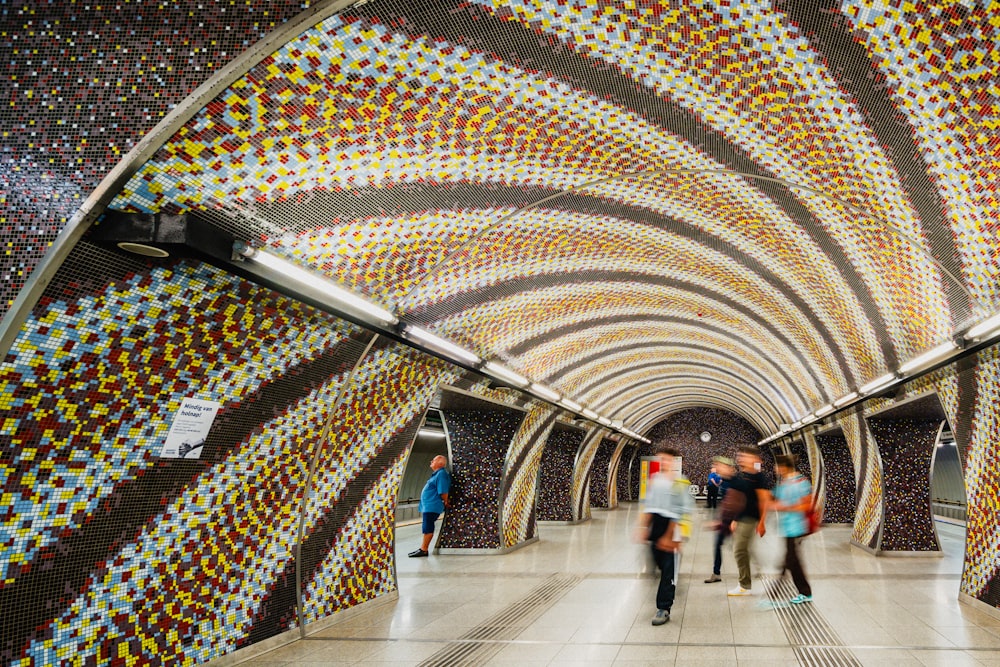 a group of people walking through a colorful tunnel