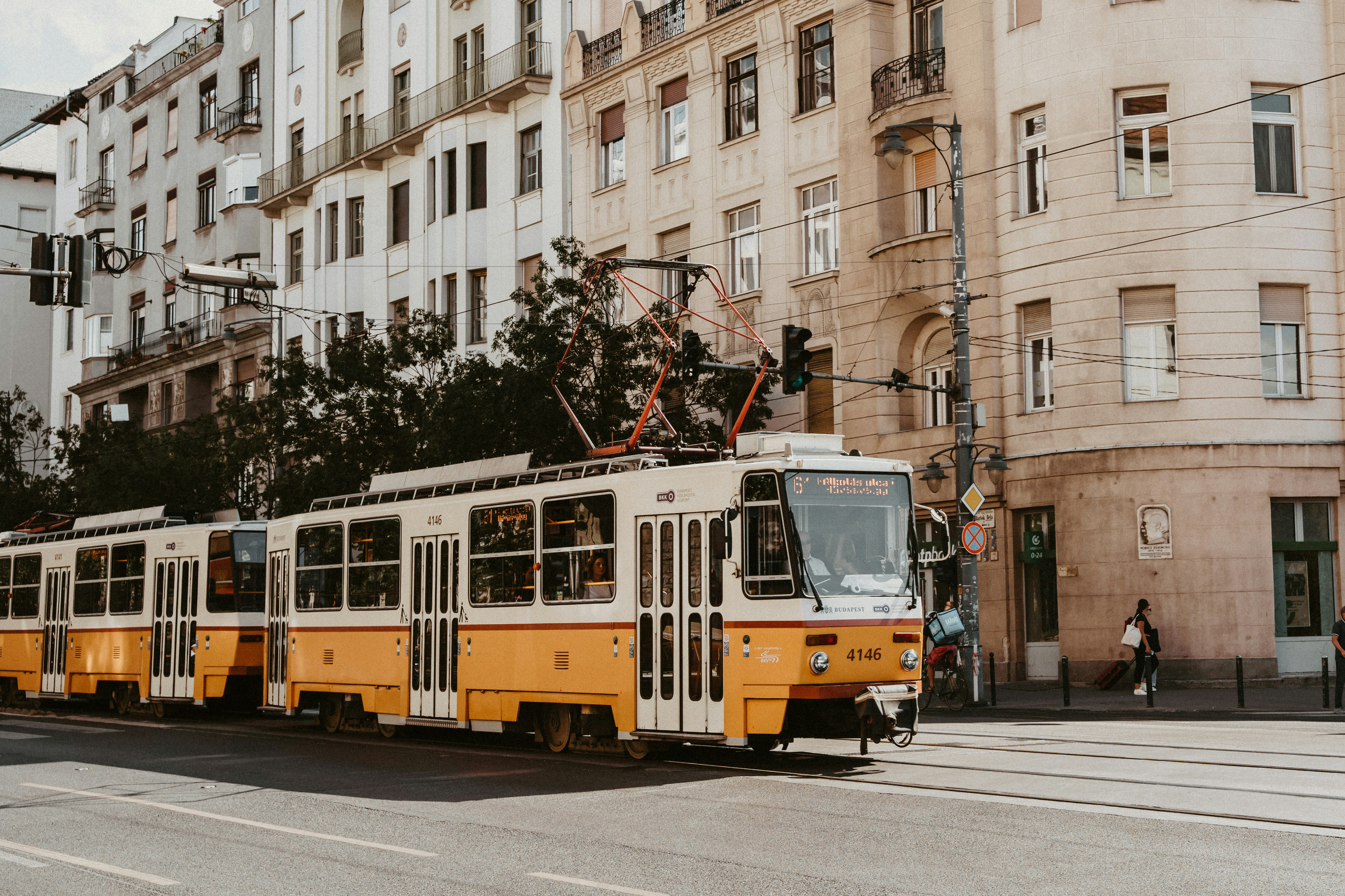 a yellow and white trolley on a city street