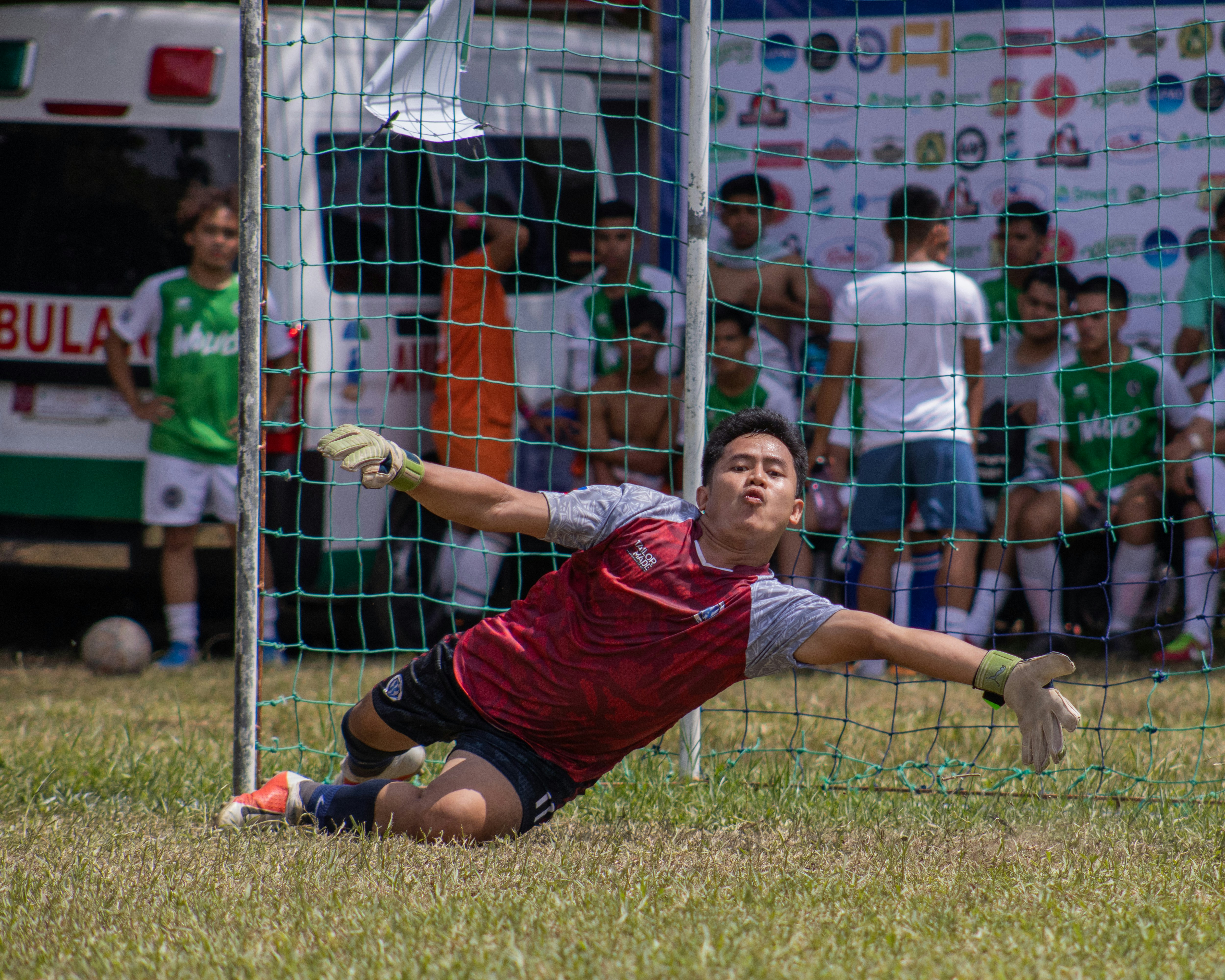 a young man diving to catch a soccer ball