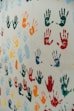 a group of multicolored hand prints on a white wall