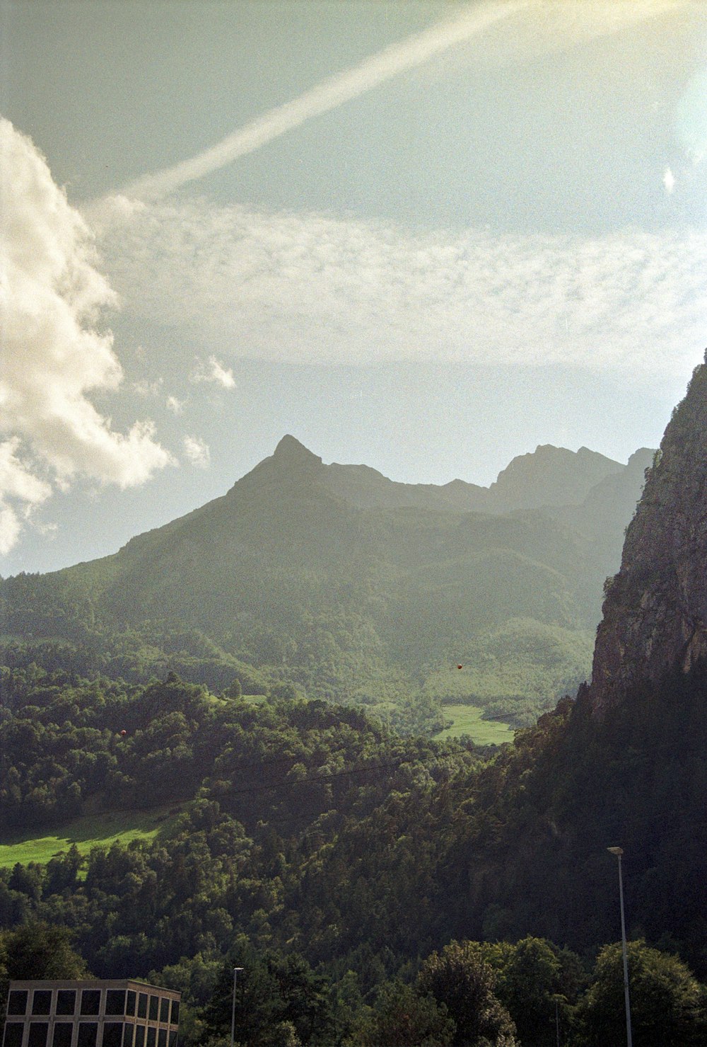 a view of a lush green valley with mountains in the background