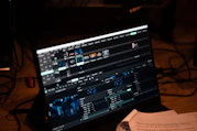 An editor working on a computer with video editing software and multiple screens.