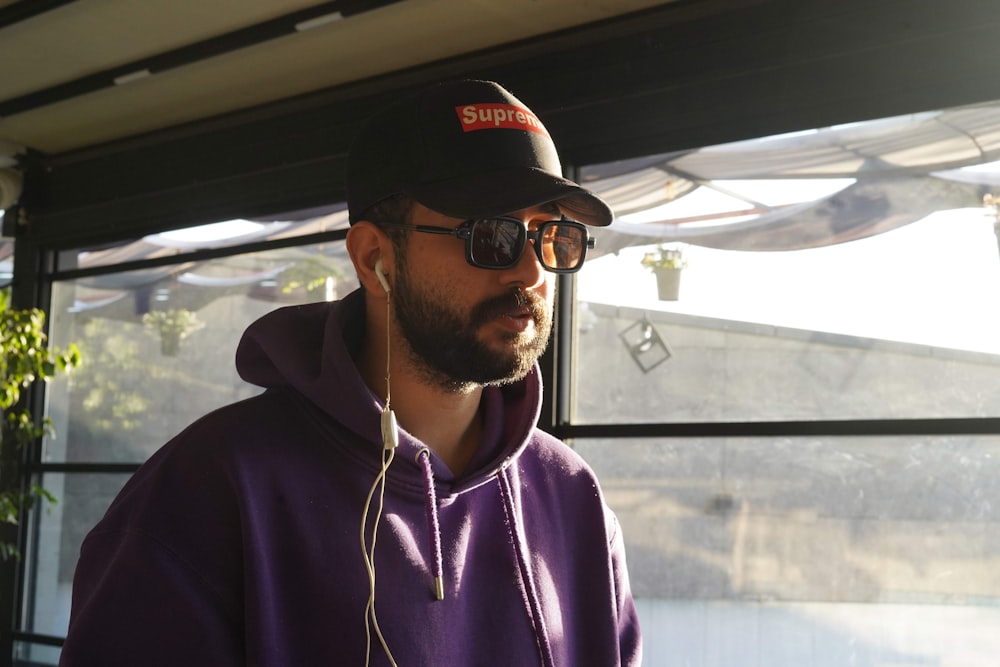 a man in a purple hoodie listening to headphones