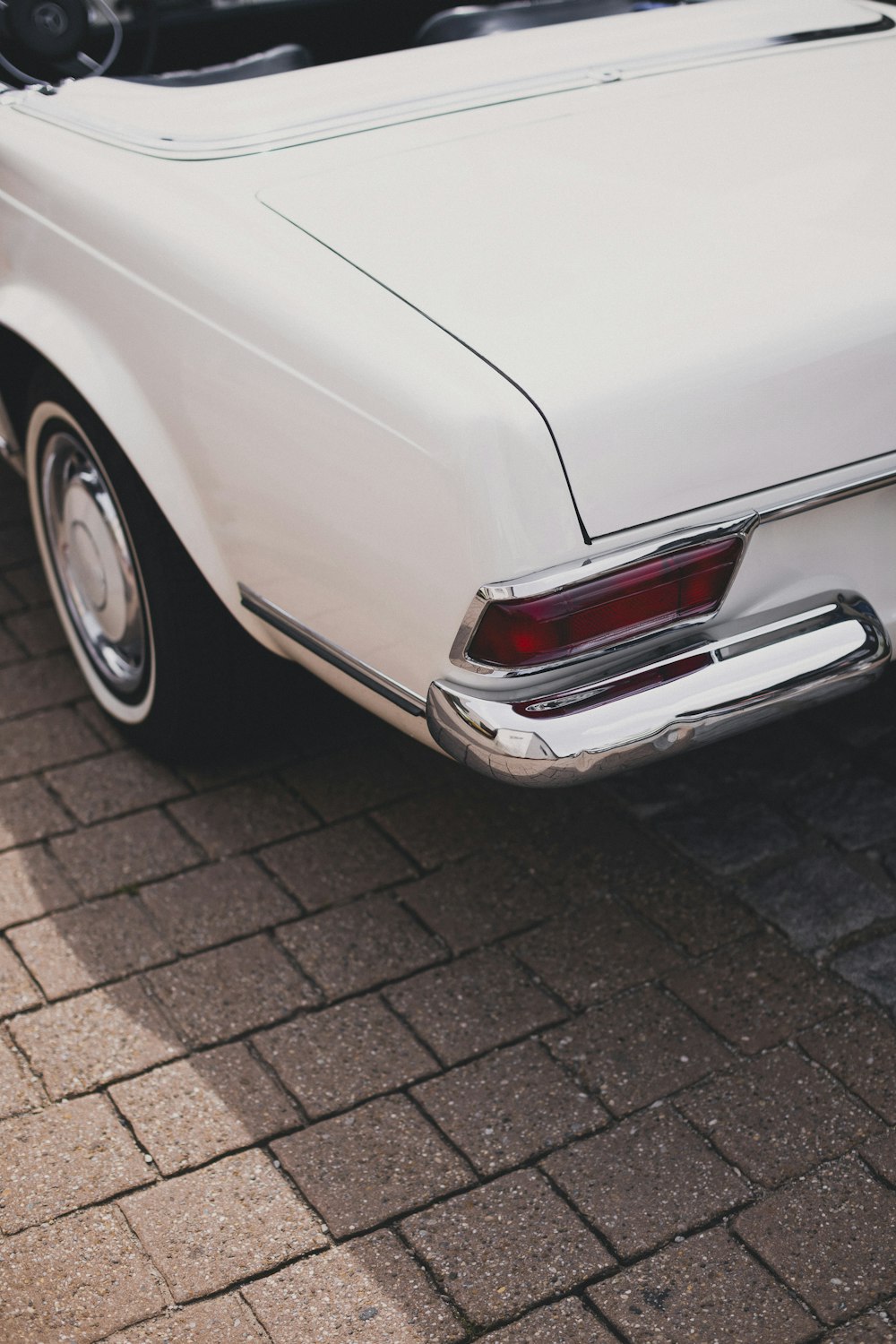 a white car parked on a brick road