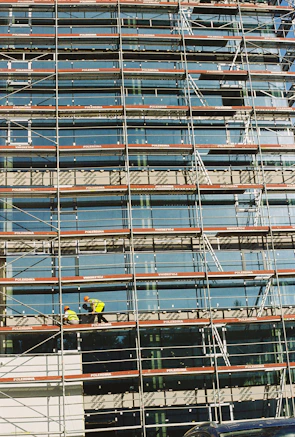 Construction site showing workers and scaffolding on a commercial building facade.