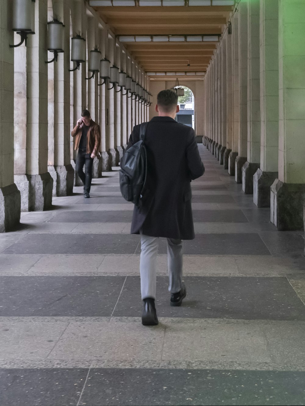 a man is walking down a long hallway