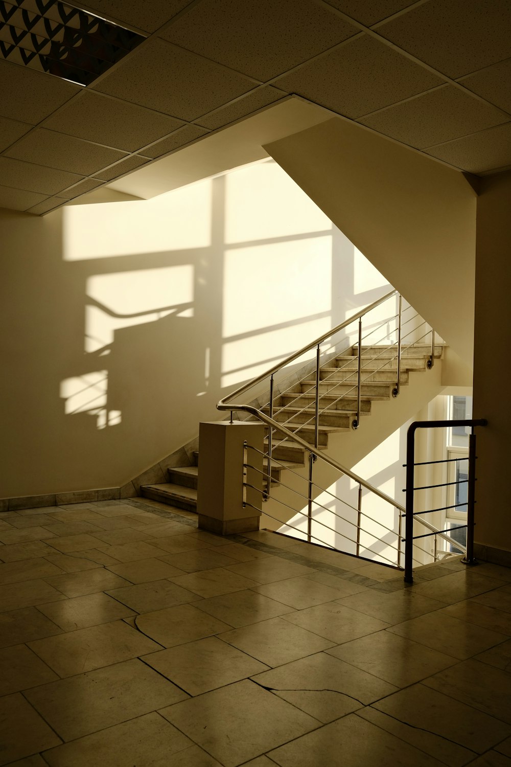 a staircase in a building with a light coming through the window