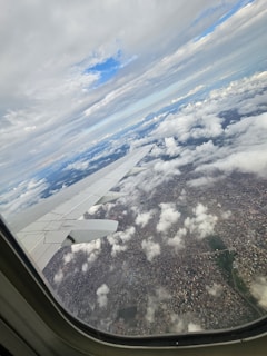 Aerial shot of a private jet soaring above the clouds with a hint of cityscape below