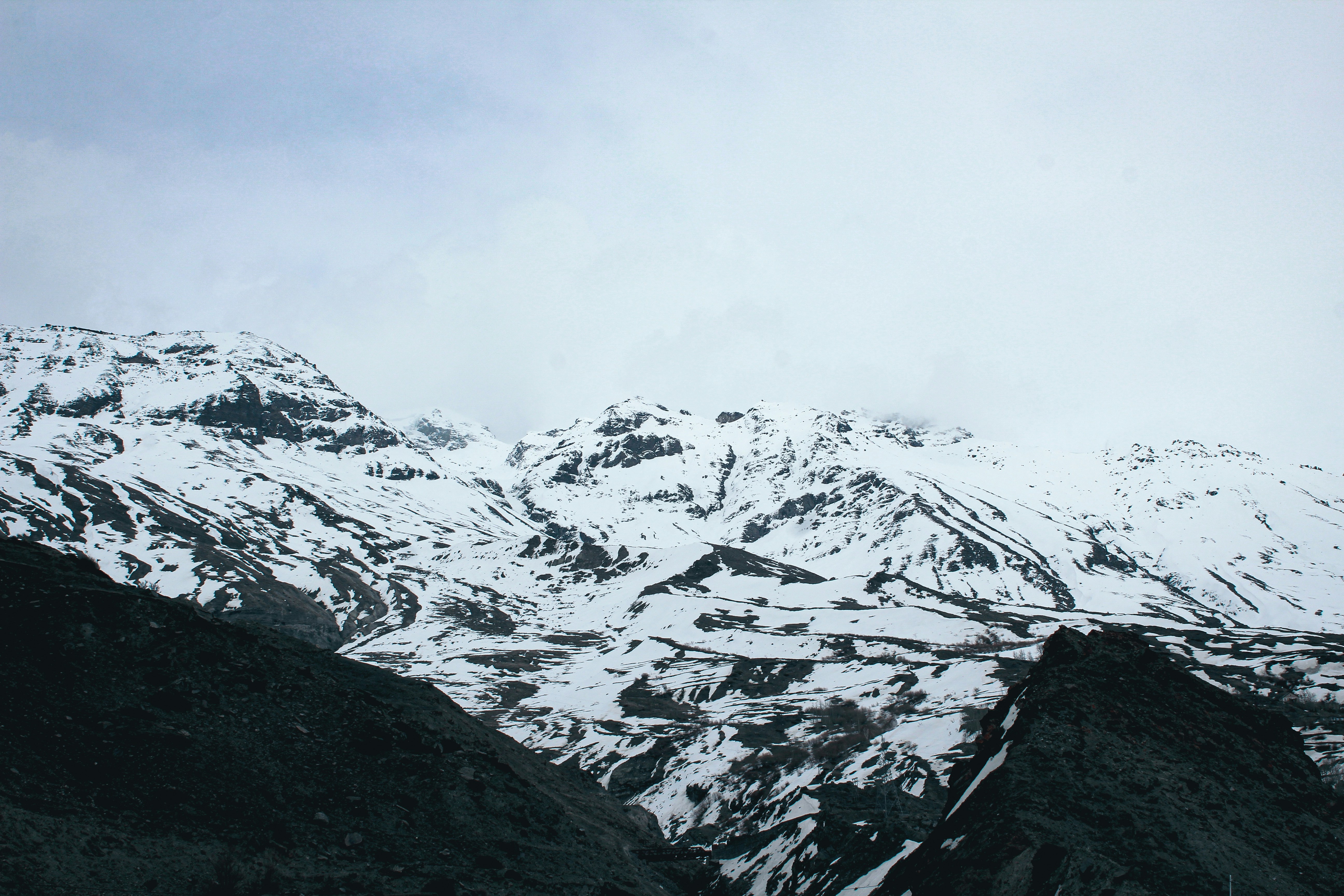 a mountain covered in snow with a sky background, 
