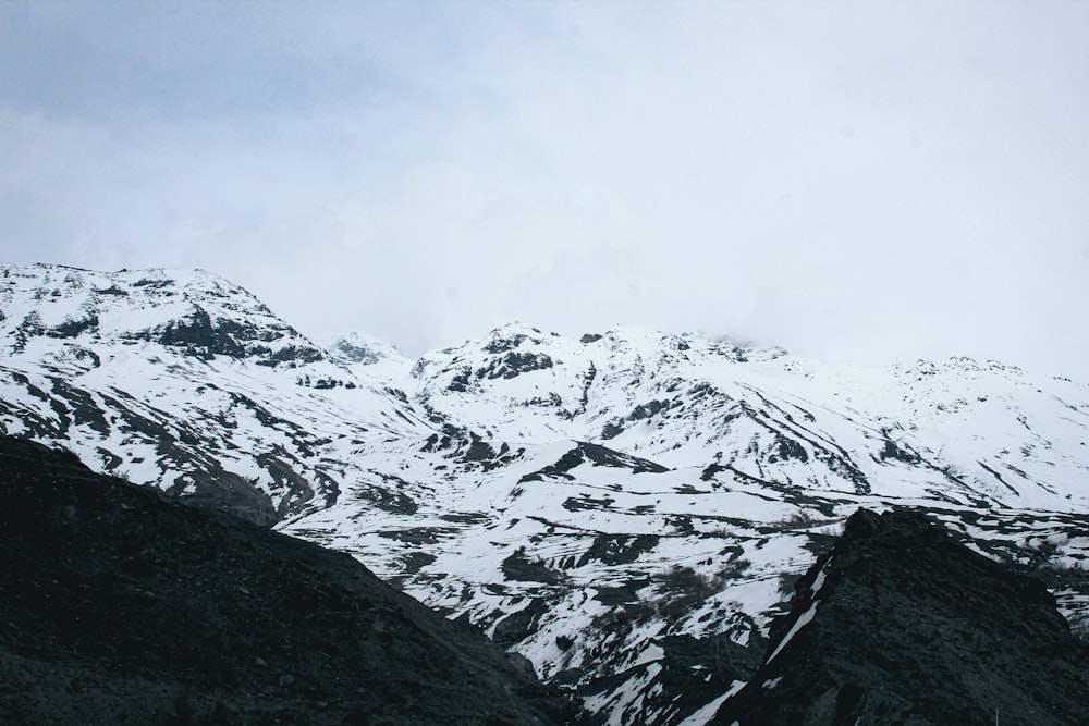 uma montanha coberta de neve com um fundo de céu