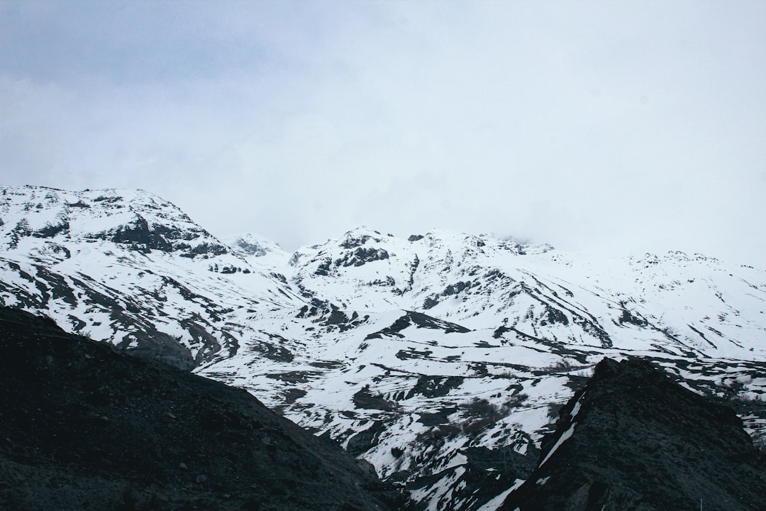 a mountain covered in snow with a sky background,