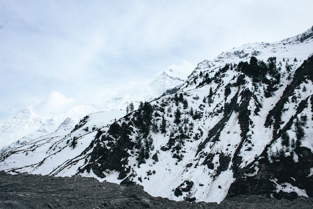 uma montanha coberta de neve com um fundo de céu