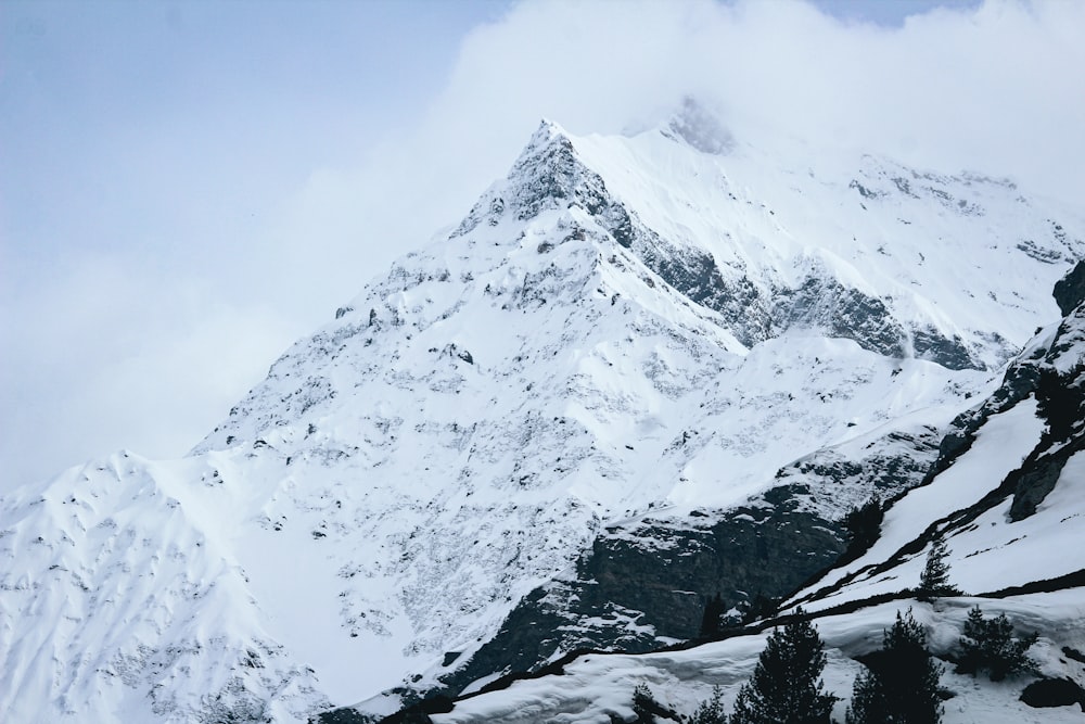 uma montanha coberta de neve com um fundo de céu