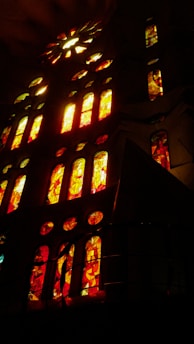 A warm, inviting church interior bathed in soft orange light highlighting stained glass windows.