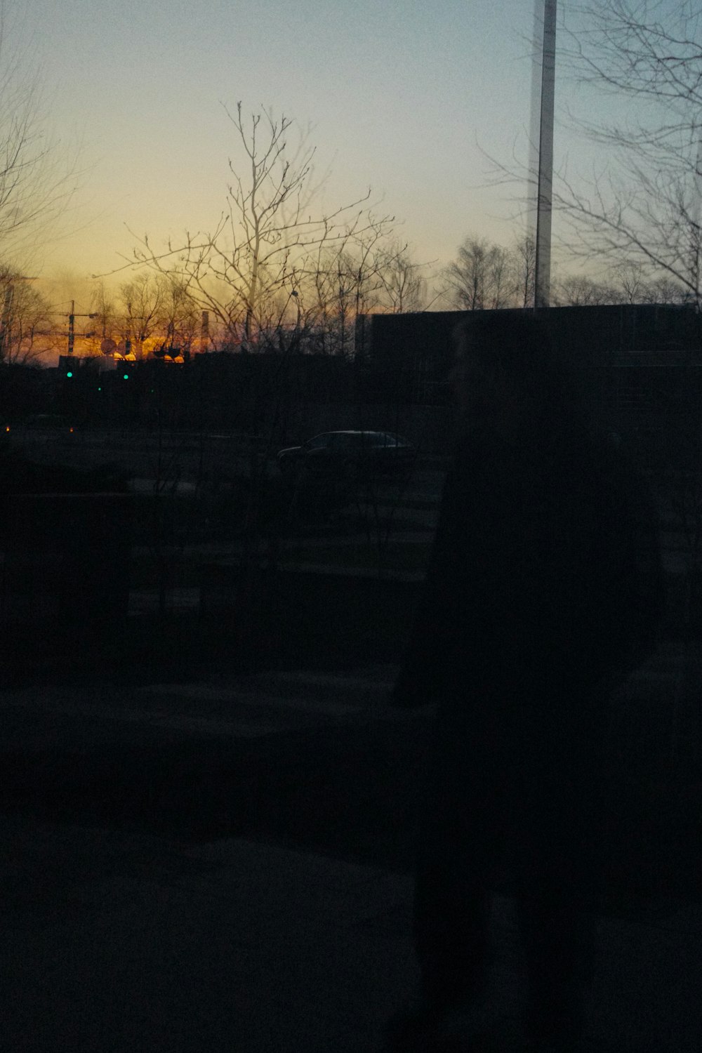 a man standing in a parking lot at sunset