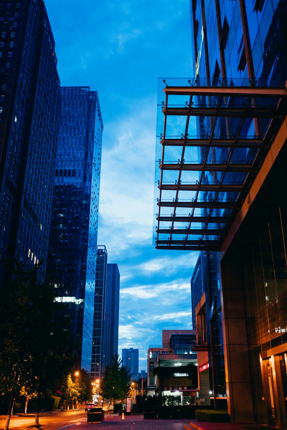 a city street at night with tall buildings