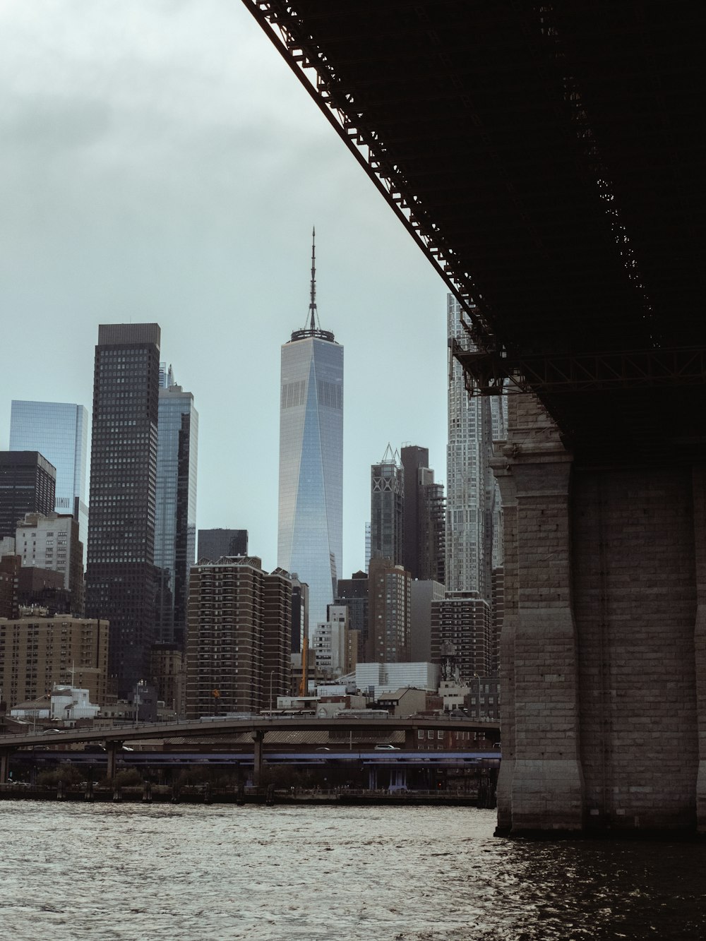 a view of a city from a river under a bridge