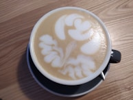 A steaming cup of cappuccino with latte art.