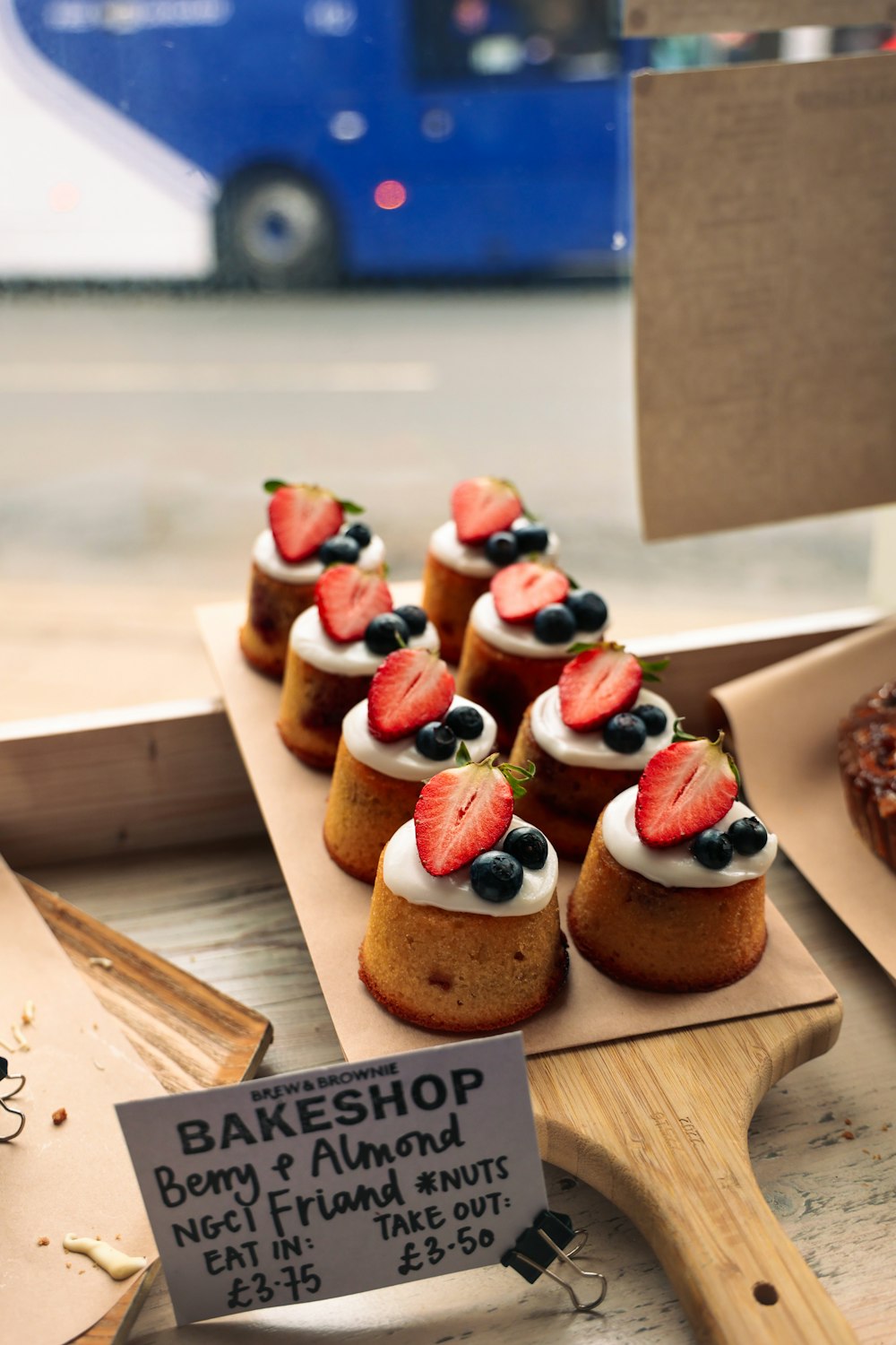 a display of pastries with strawberries and blueberries on them