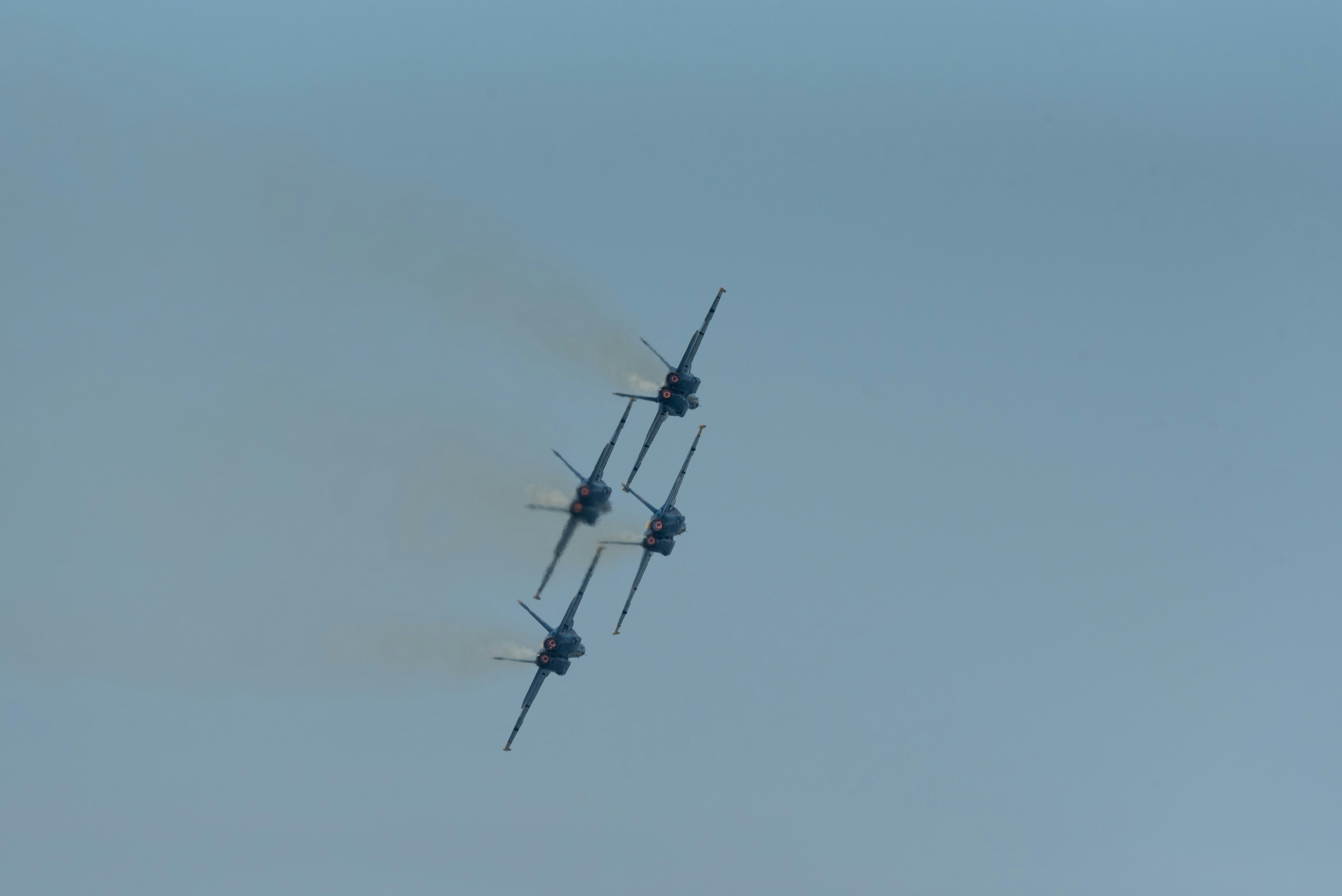 two airplanes flying in the sky with smoke coming out of them