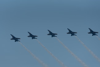 a group of fighter jets flying through a blue sky